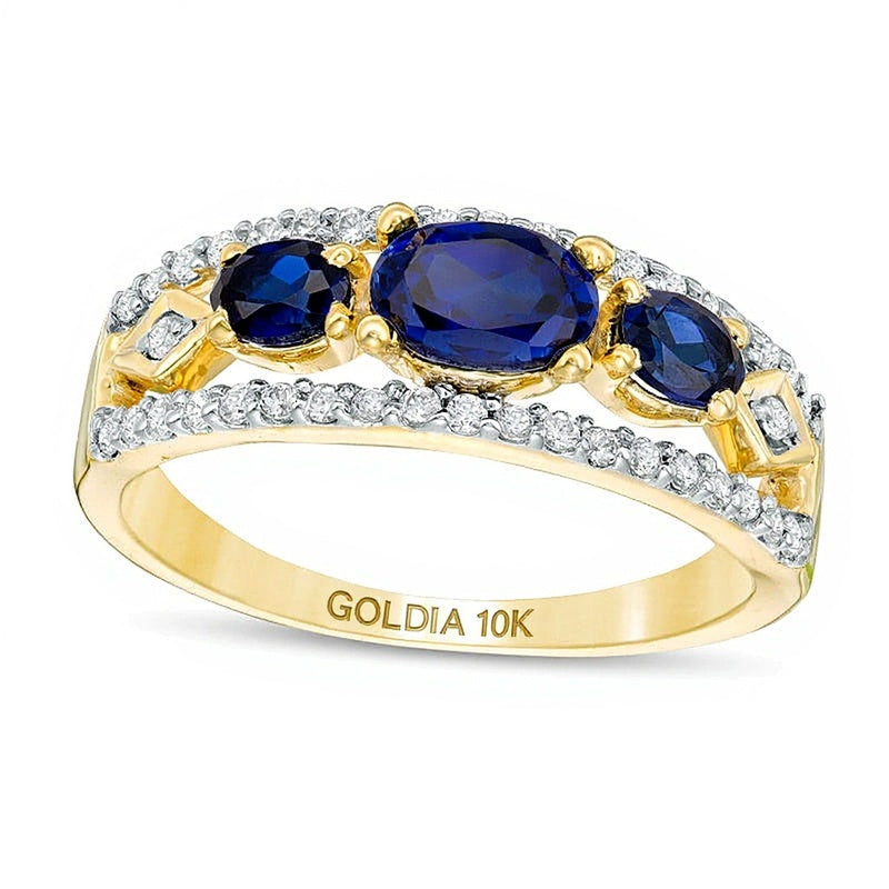Dreistein-Ring mit querliegendem ovalem, im Labor gezüchtetem blauem Saphir und 0,25 ct. Gesamtgewicht Diamanten in 10K Gelbgold