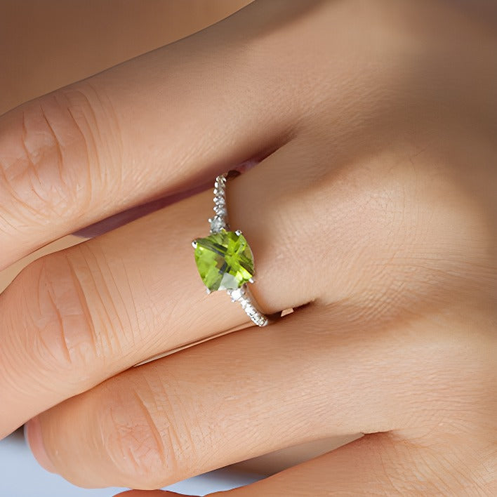7,0mm Peridot im Kissenschliff und 0,13 ct. Gesamtgewicht Diamant Verlobungsring als Solitär mit seitlichem Besatz in 10K Weißgold