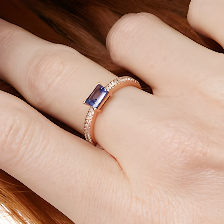 Solitär mit seitlichem Besatz mit Tansanit im Smaragdschliff und 0,1 ct. Gesamtgewicht Diamanten in 14K Roségold