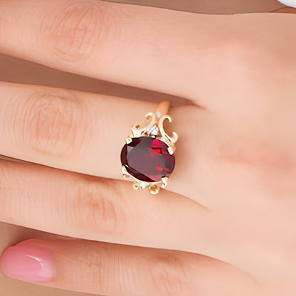 Ring mit ovalem Granat und 0,05 ct. Gesamtgewicht Diamanten mit verziertem Rahmen in 10K Gelbgold