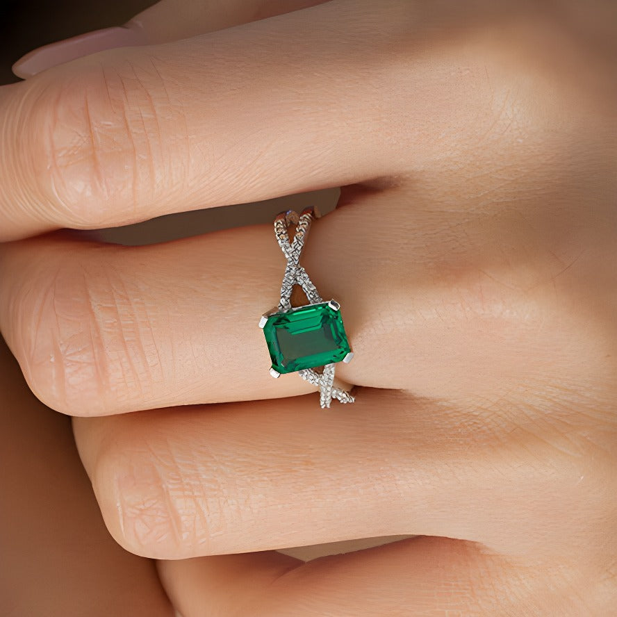 Ring mit Smaragd im Smaragdschliff (Labor) und 0,1 ct. Gesamtgewicht Diamanten mit Criss-Cross-Split-Shank in 10K Weißgold